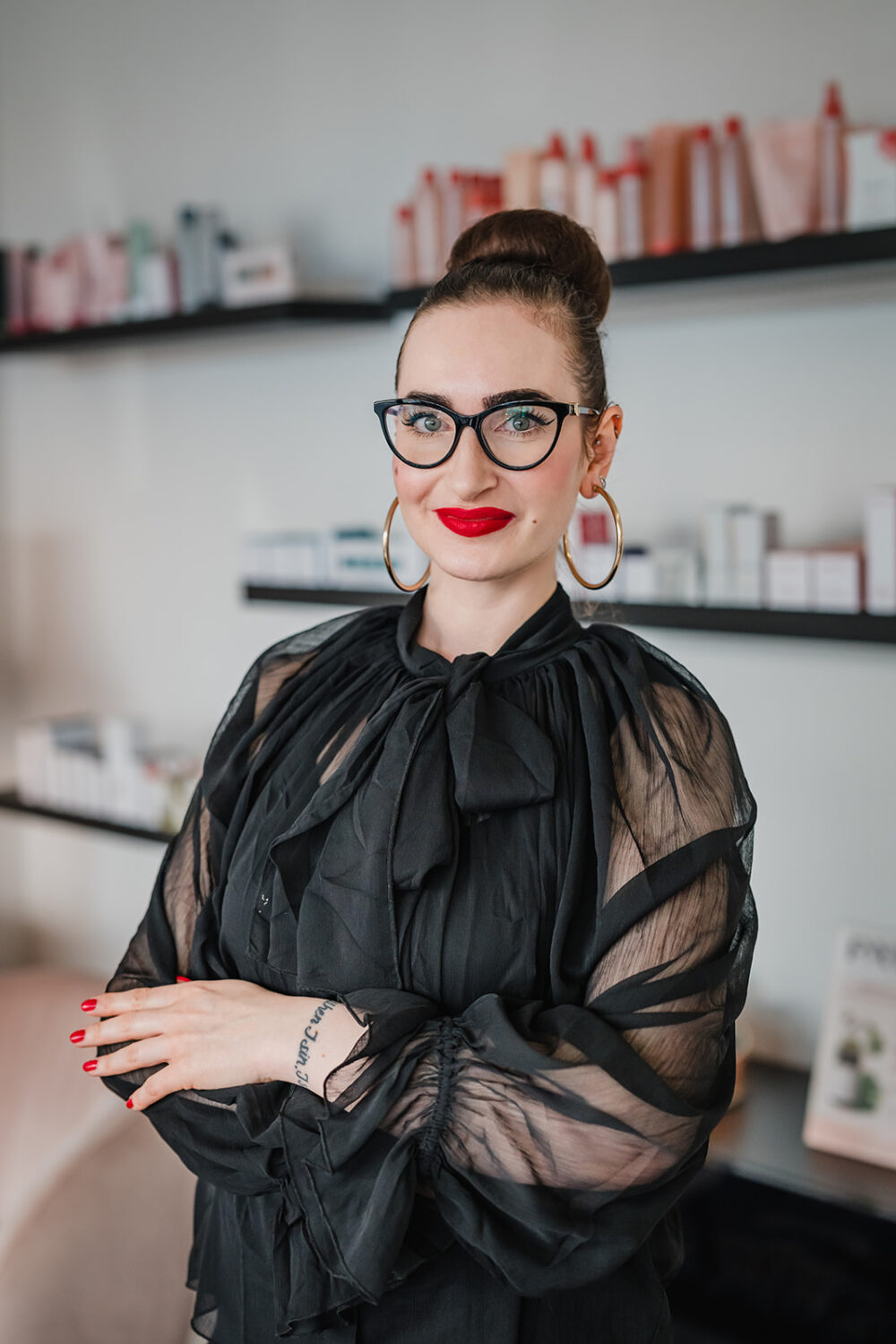 Portrait einer Make-Up-Artist mit rotem Lippenstift und schwarzer Brille