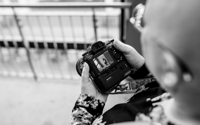 Fotografin schaut auf ihr Kameradisplay und sieht eines der Bilder an